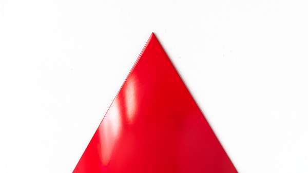 Eine rote Pylone vor weißem Hintergrund