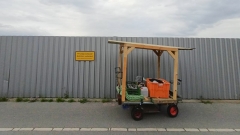 Ein Holzwagen vor einem metallenen Baustellenzaun