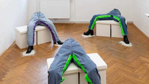 Jeans with Velcro fasteners on the insides of the legs are arranged on three pedestals.