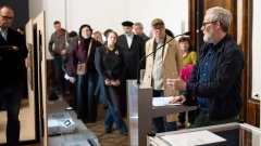 Kurator Robert Müller hält eine Eröffnungsrede vor Publikum