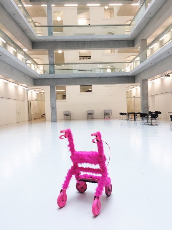 Pinker Plüsch-Rollator steht im Auditorium der Universität für angewandte Kunst Wien, Standort
                                          Vordere Zollamtsstraße 7, 1030 Wien