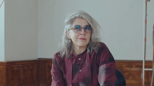 Die Künstlerin Leonor Antunes sitzend in ihrer
                                          Ausstellung