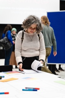 Eine Frau blättert durch eine Publikation bei einem Workshop